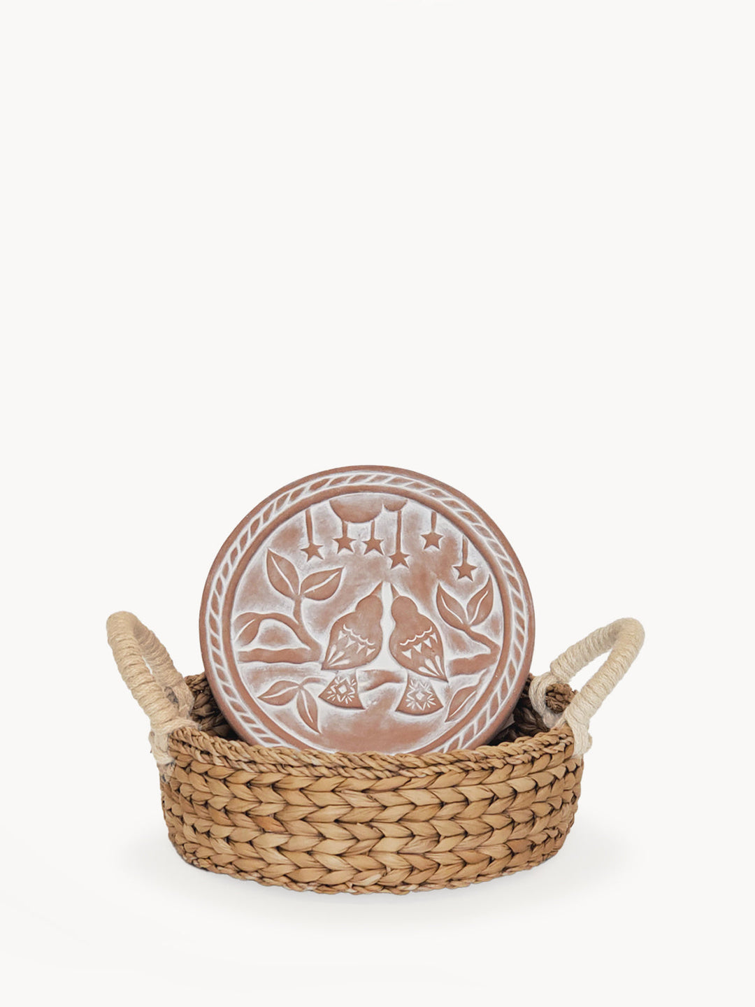 Round terracotta bread warmer engraved with lovebirds in a woven seagrass basket