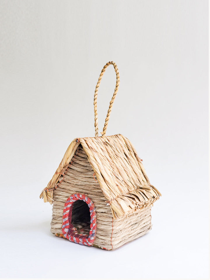Natural seagrass woven birdhouse, cabin form, with sari fabric trim around entry