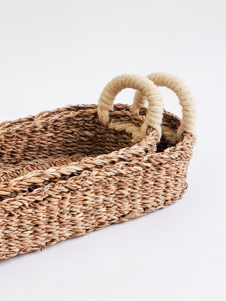 Seagrass bread basket with white handles for serving bread and baked goods