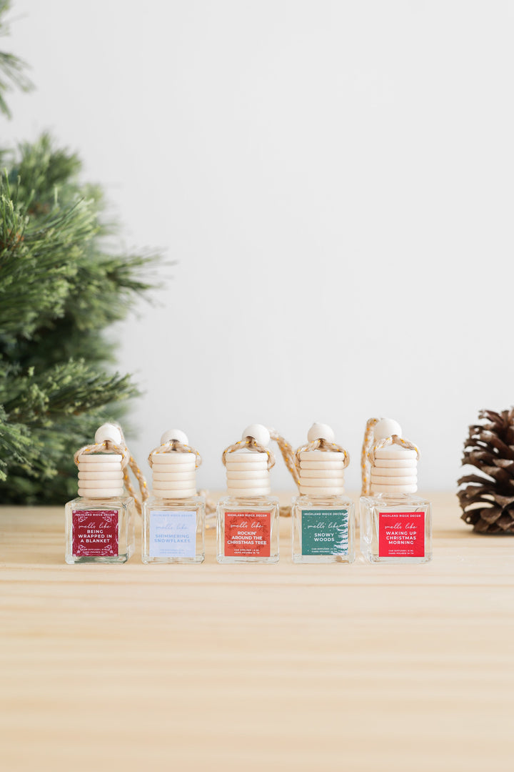 Snowy Woods car diffuser with a wooden cap and winter-forest design.
