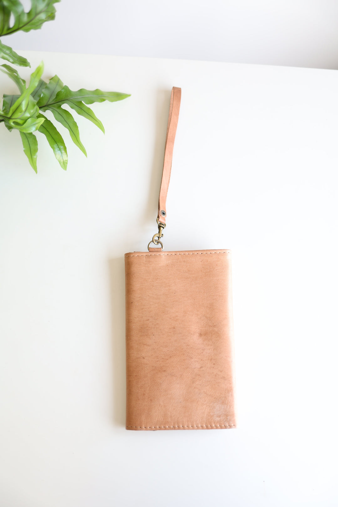 Handmade leather wristlet wallet with visible stitching detail.