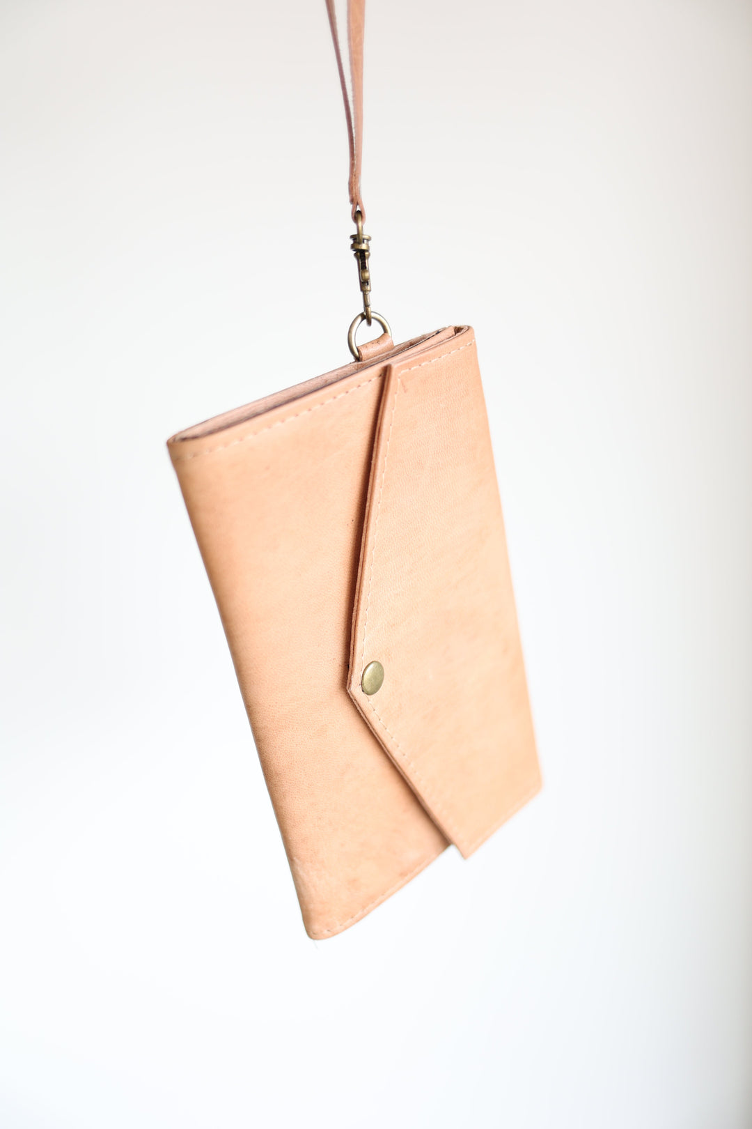 Handmade leather wristlet wallet with card slots and a zip closure.