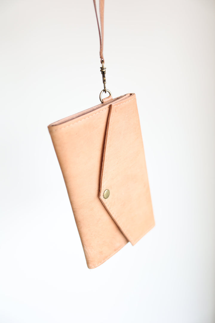 Handmade leather wristlet wallet with card slots and a zip closure.