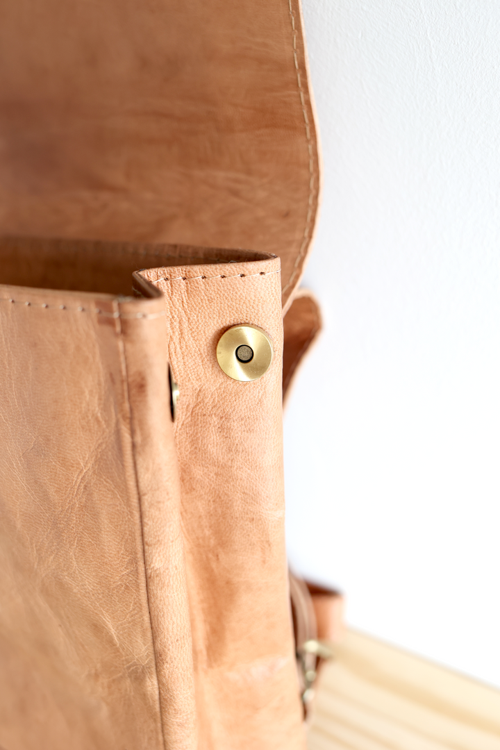 Small leather backpack with a roomy interior and a zippered pocket.
