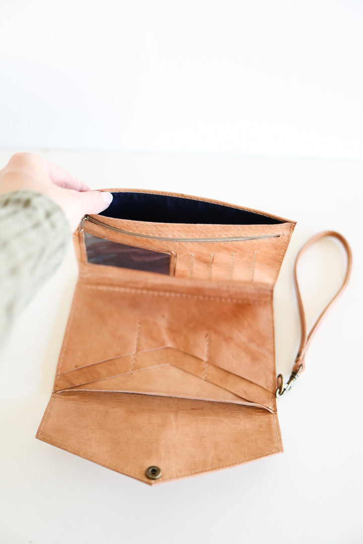 Handmade leather wristlet wallet with a leather strap and card slots.