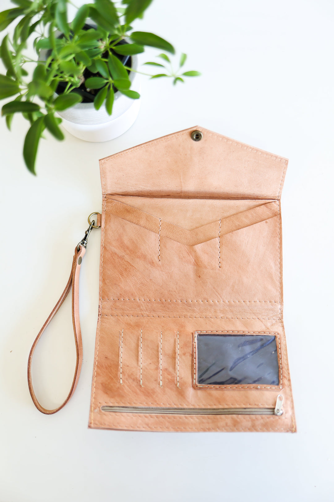 Handmade brown leather wristlet wallet with card slots and a wrist strap.