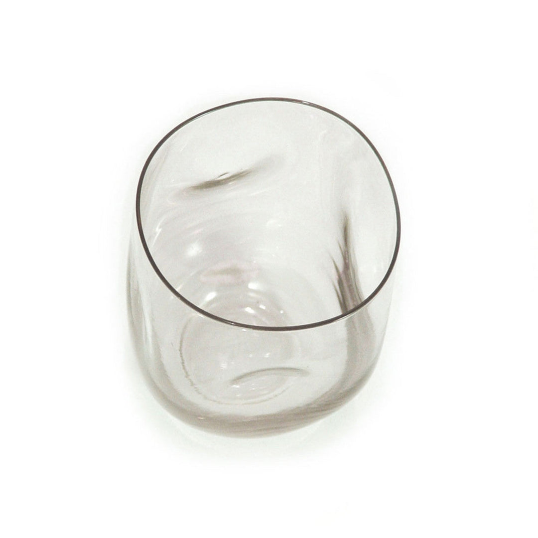 Recycled-glass dented water glass with a textured, eco-friendly stemless design.