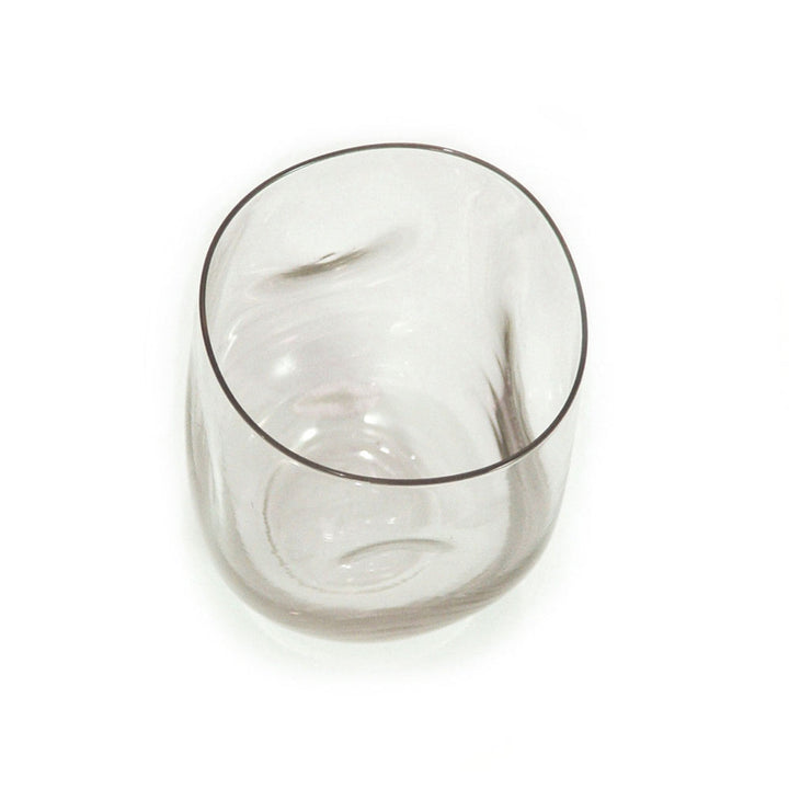 Recycled-glass dented water glass with a textured, eco-friendly stemless design.