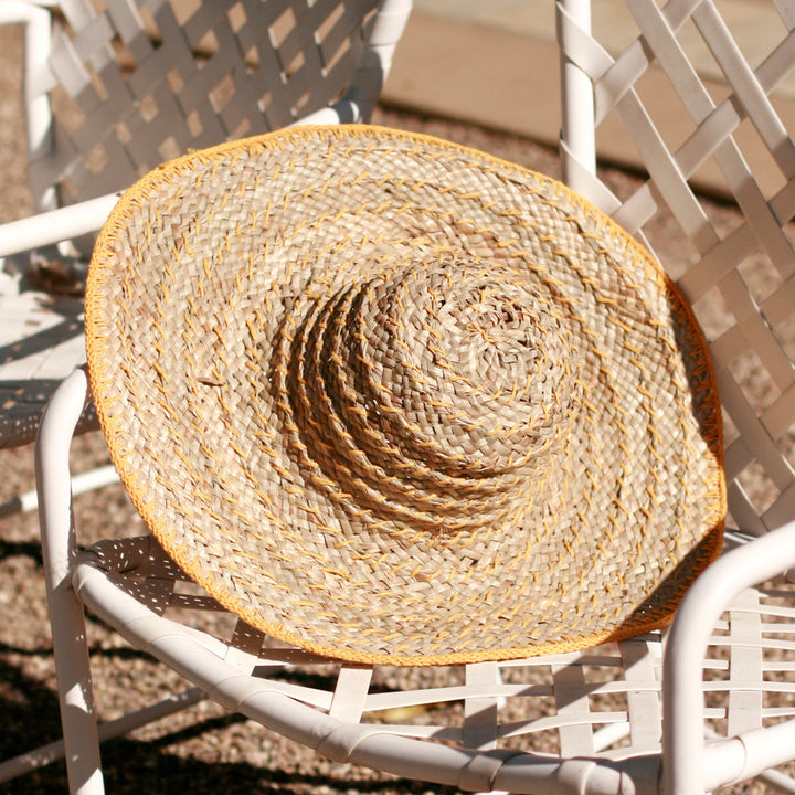 Butter yellow wide round straw hat with a relaxed, sun-shielding design and casual Balinese style.