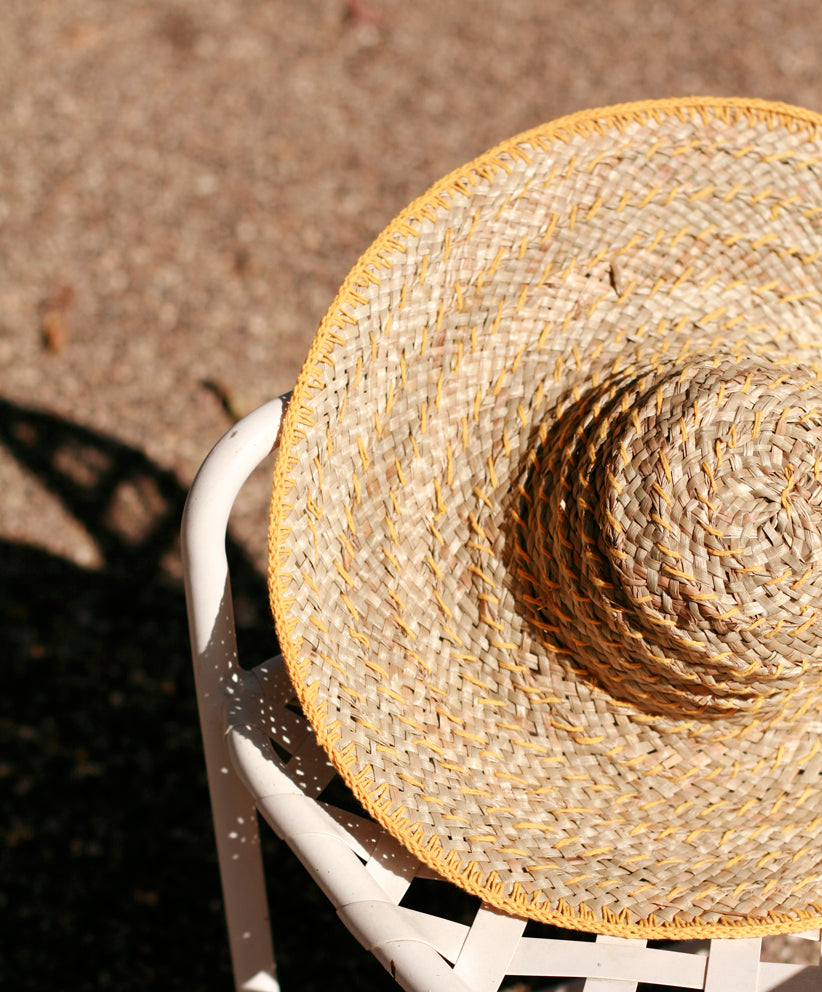 Butter yellow wide round straw hat with a Bali-inspired design and wide brim for sun coverage.