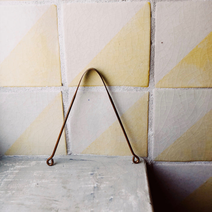 Copper tongue scraper on a white background.