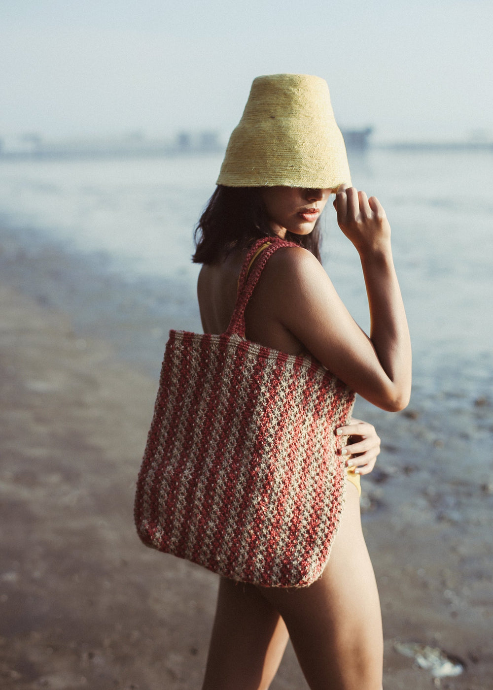 Striped straw tote bag made of natural jute with brown and white stripes, eco-friendly design.