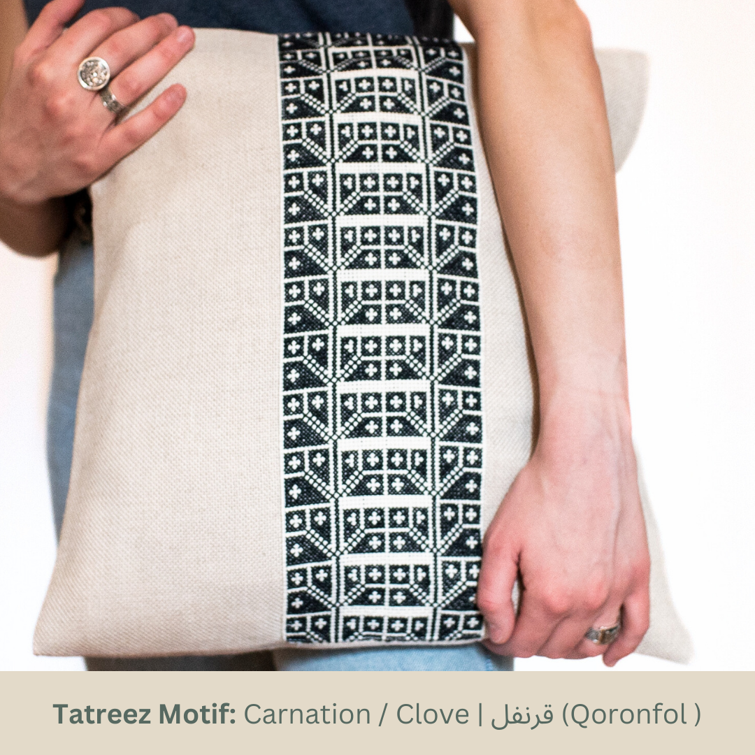 Natural oatmeal pillow cover with a vertical black-and-white Carnation tatreez band.
