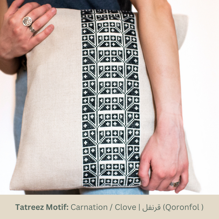 Natural oatmeal pillow cover with a vertical black-and-white Carnation tatreez band.