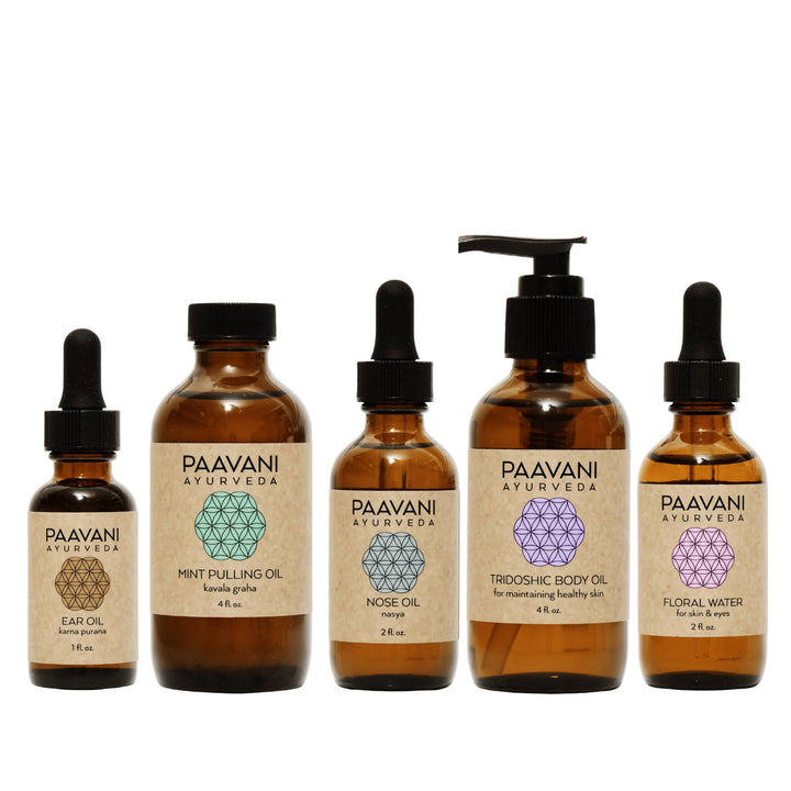 Dinacharya Ayurvedic self-care kit with oils and tools.