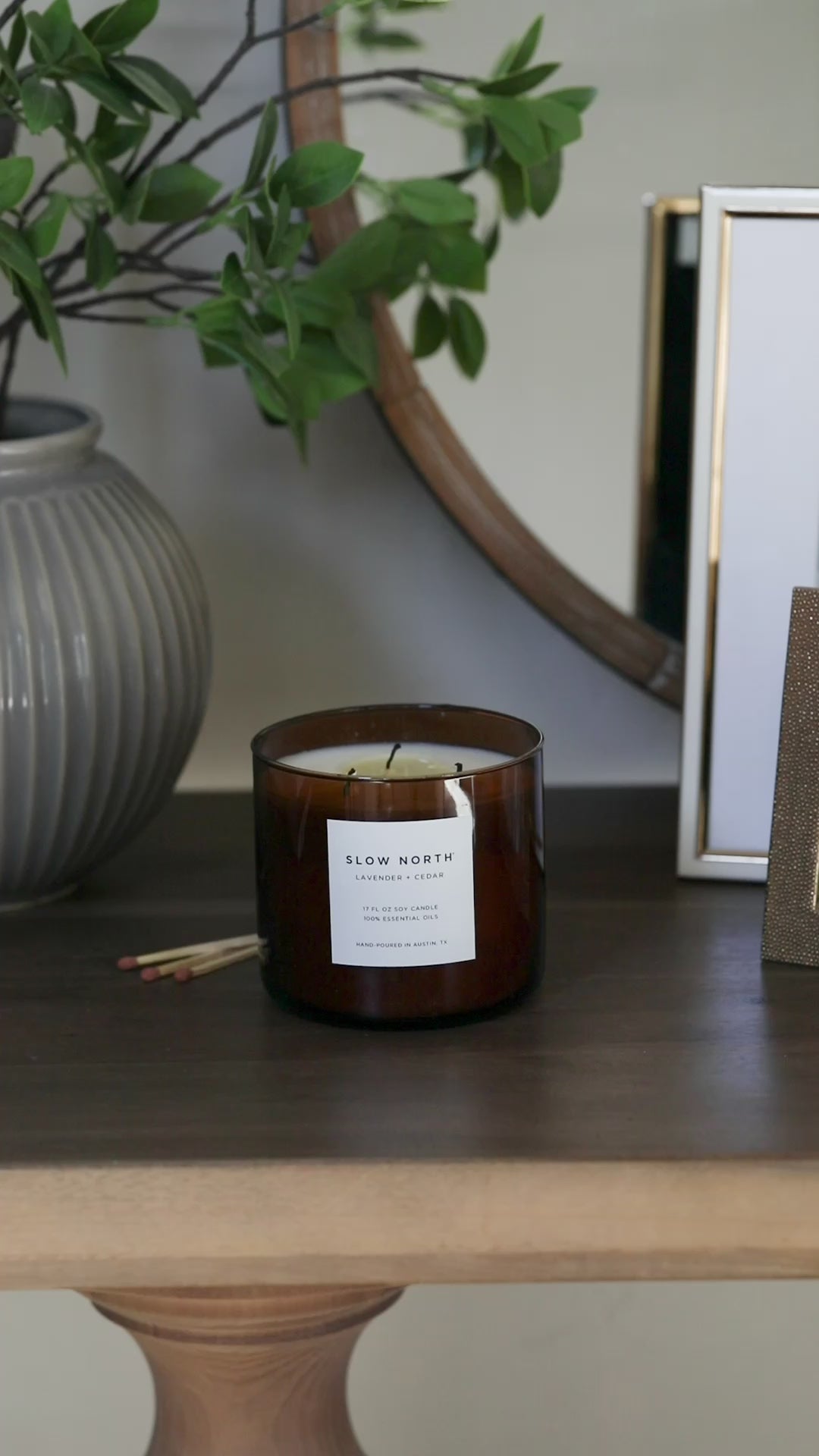 Lavender Cedar three-wick candle in an elegant glass jar with a lit wick.