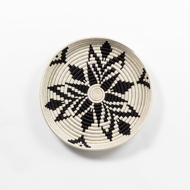 Overhead view of a large flat-bottomed Boutique Cactus Blossom woven bowl in cream and black.