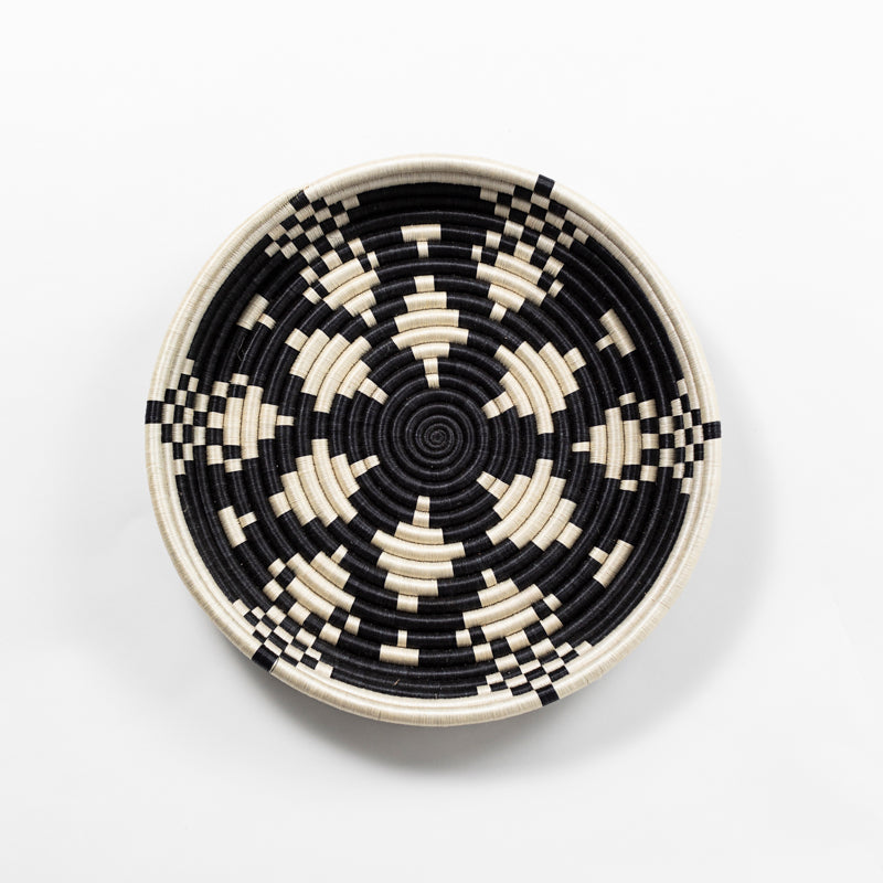 Overhead view of a large Boutique Kaleidoscope woven bowl with a black and cream geometric pattern.