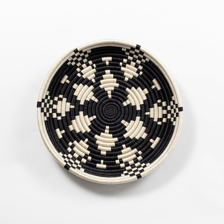 Overhead view of a large Boutique Kaleidoscope woven bowl with a black and cream geometric pattern.