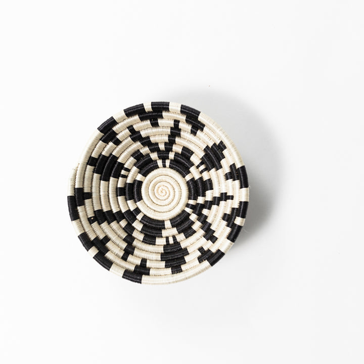 Overhead view of a small Boutique Shamrock woven bowl in black and cream.