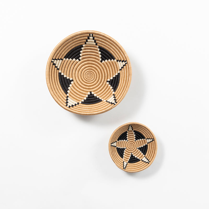 Small and medium Boutique Vertex woven bowls in tea-dyed sisal with a black and ivory pinwheel pattern.