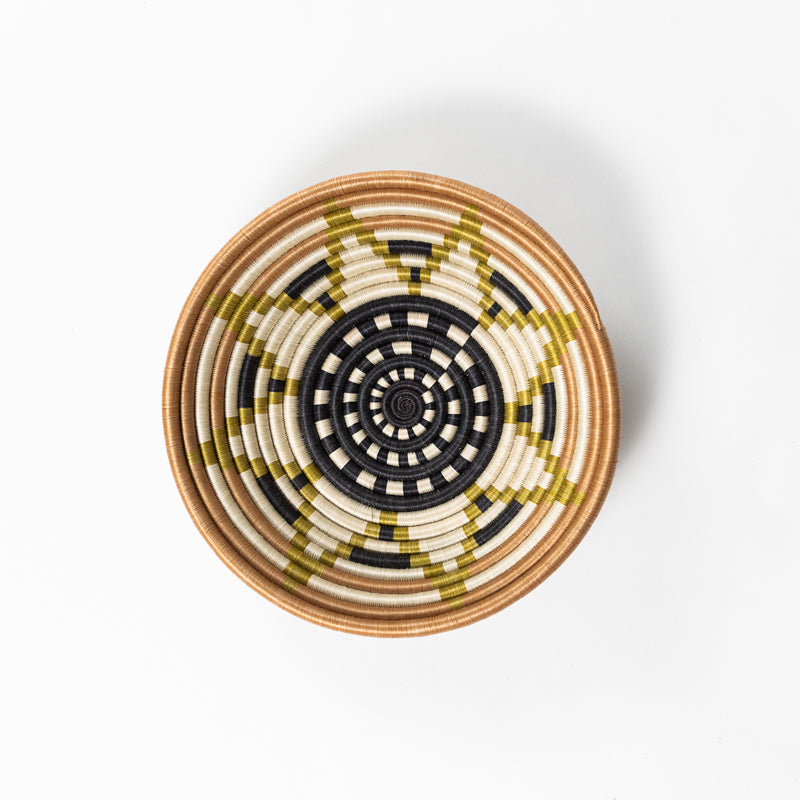 Overhead view of a medium Boutique Vestine green woven bowl with a star pattern.