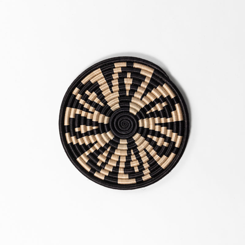 Handwoven sisal trivets in assorted geometric patterns, tea and black.