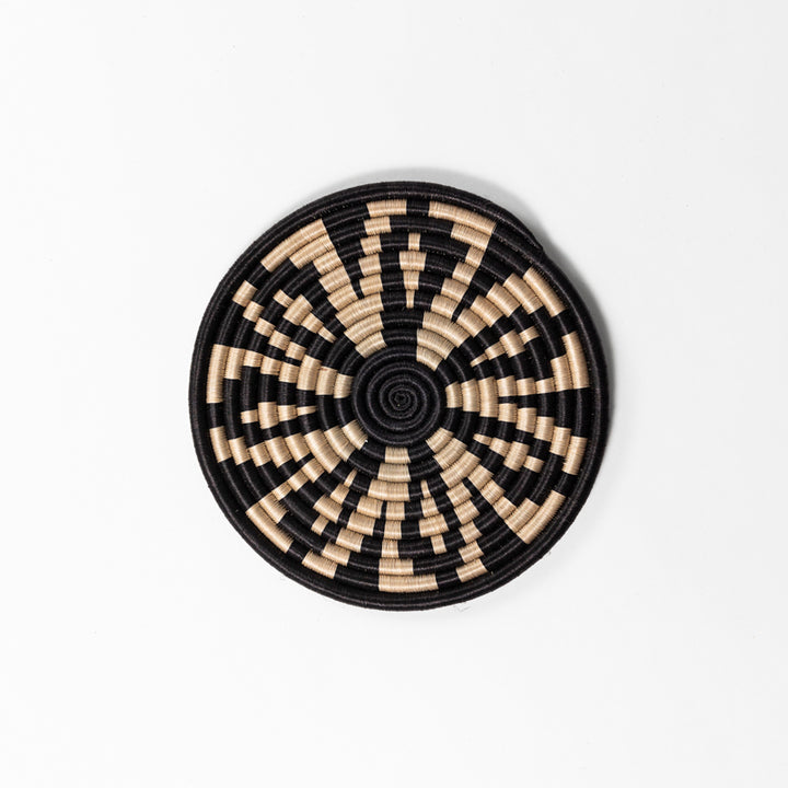 Handwoven sisal trivets in assorted geometric patterns, tea and black.