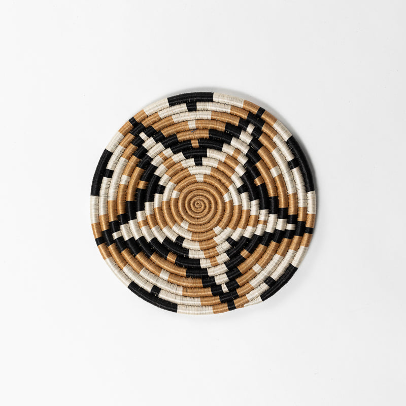 Handwoven sisal trivet with a starburst design in natural fiber.
