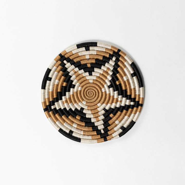 Handwoven sisal trivet with a starburst design in natural fiber.
