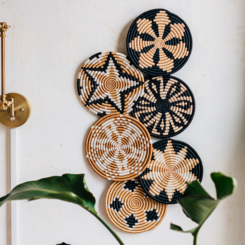 Handwoven sisal trivet in tea and black with a geometric starburst pattern.
