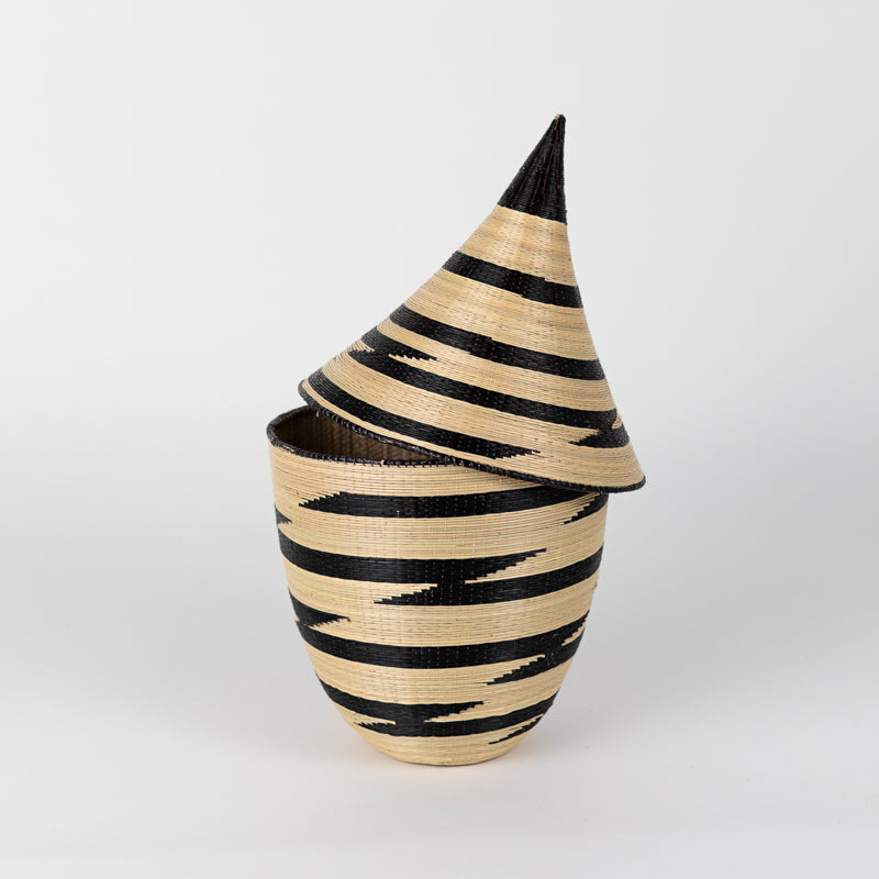 Handwoven white and black grass peace basket with a traditional lidded design.