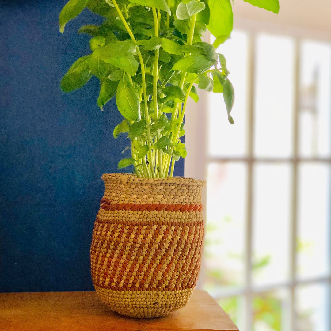 Auburn stripe Iringa basket with an intricate woven pattern in natural fiber.