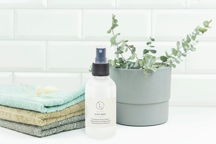 Eucalyptus 3-in-1 mist for shower, room, and fabric, in a spray bottle with eucalyptus leaves.