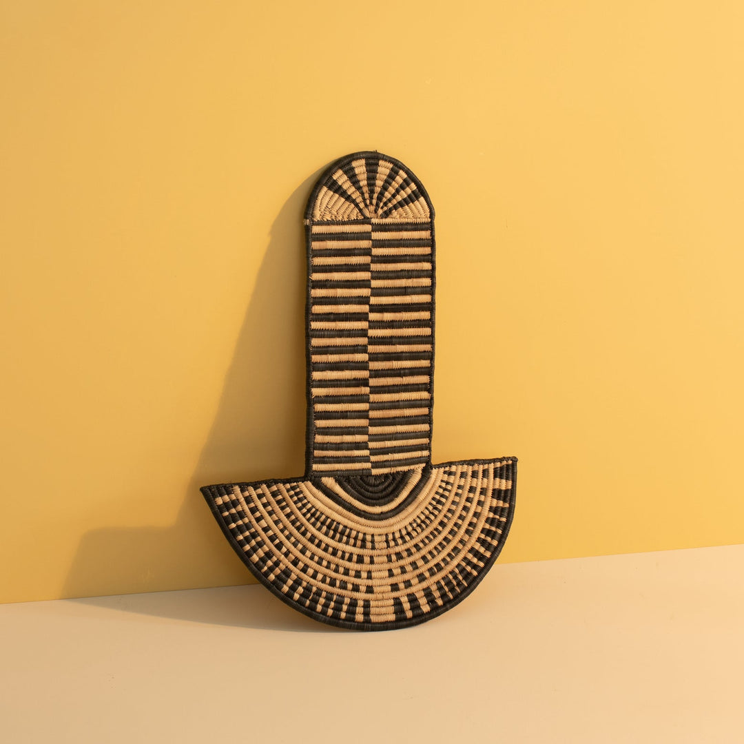 Handwoven abstract wall mask with intricate woven texture and pattern.