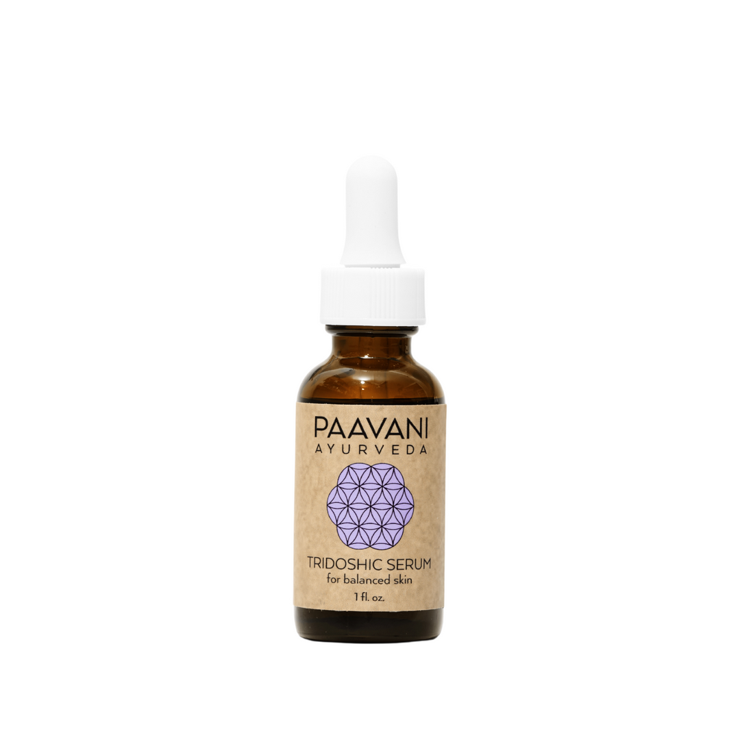 Tridoshic Ayurvedic face serum in a glass dropper bottle with herbal ingredients.