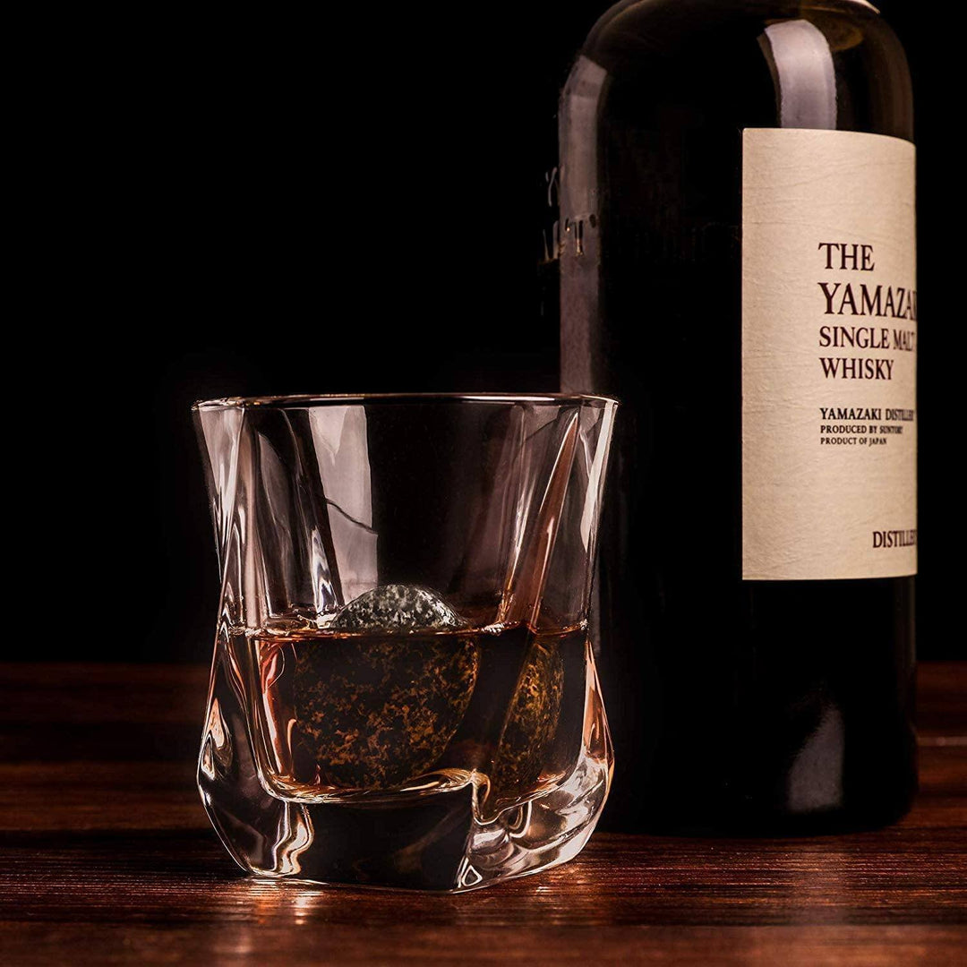 Whiskey chilling stones with a twist glass, shown on a wooden surface.