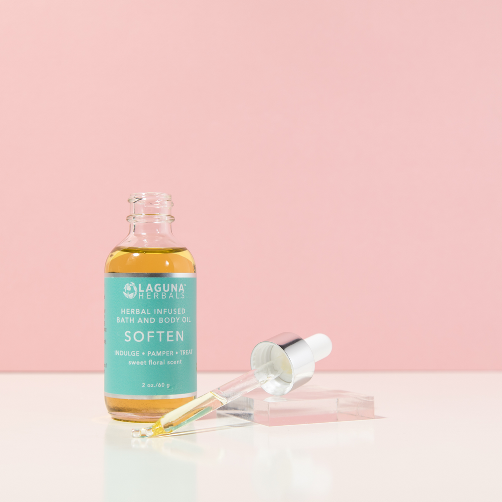 Soften jasmine rose body oil in a bottle, with jasmine and rose flowers around it.