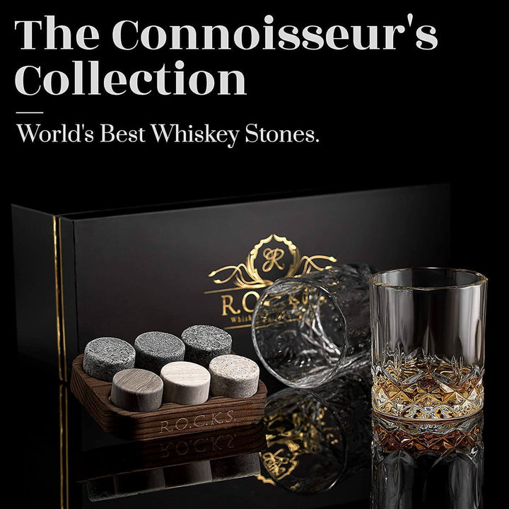 Crystal whiskey glasses with granite chilling stones on a reflective surface.