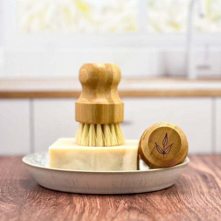 Bamboo pot brush with natural sisal bristles, a plastic-free kitchen cleaning tool.