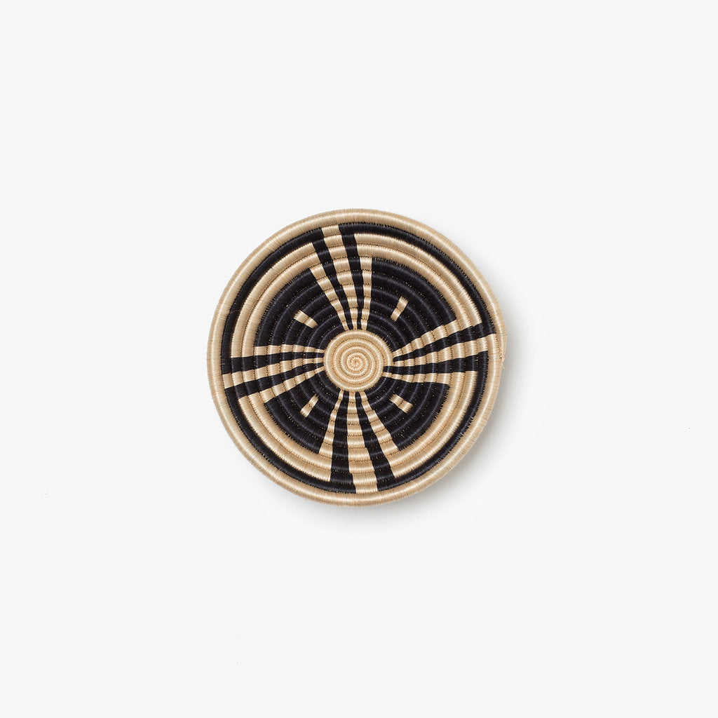 Small Akazi woven bowl in black and tea-toned sisal with a line-burst pinwheel.