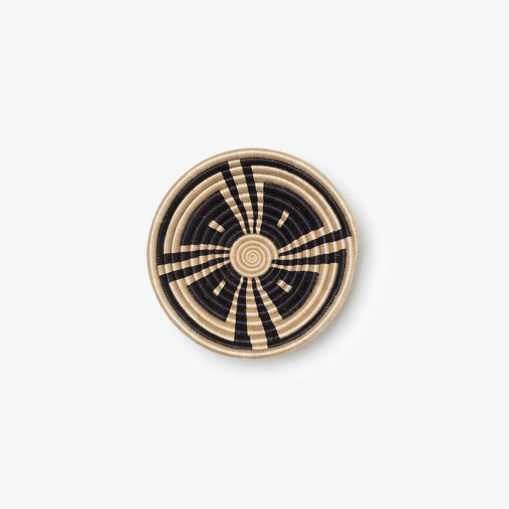 Small Akazi woven bowl in black and tea-toned sisal with a line-burst pinwheel.