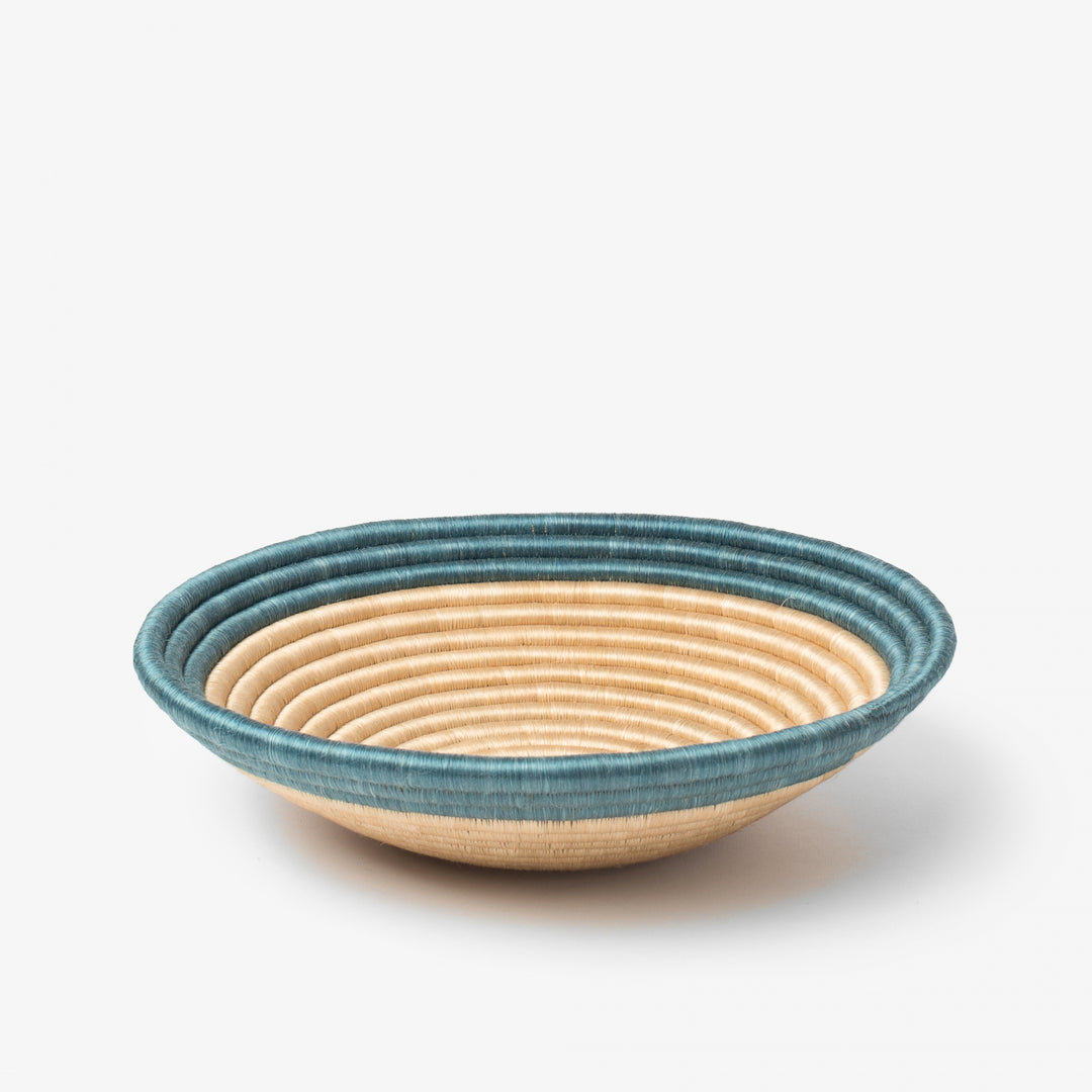 Medium Aura woven bowl with a teal rim band over natural tea-toned sisal.