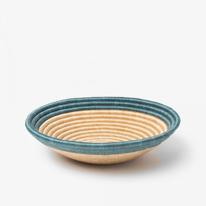 Medium Aura woven bowl with a teal rim band over natural tea-toned sisal.