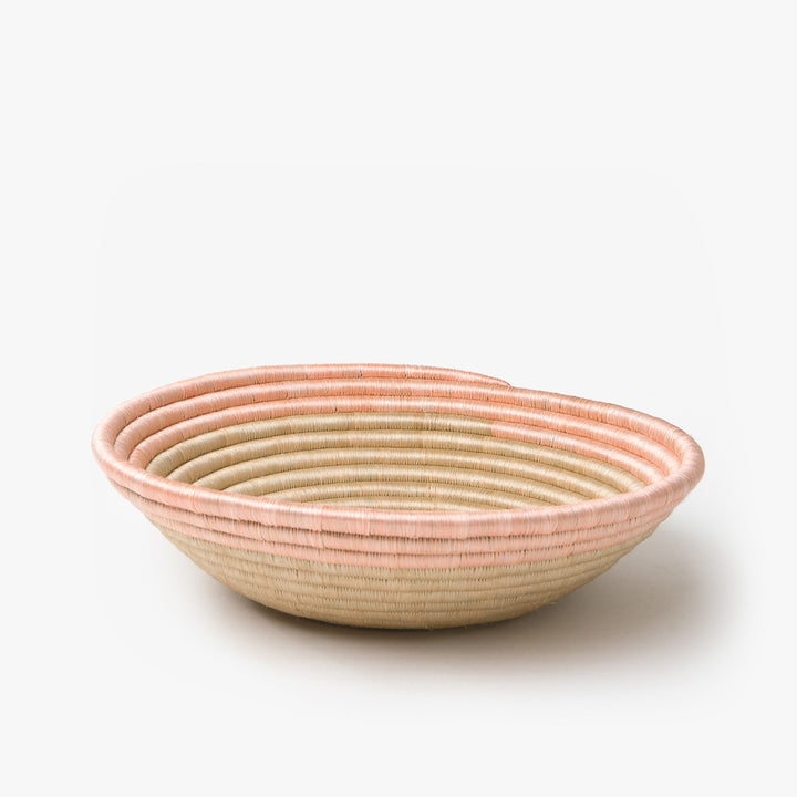 Medium Aura woven bowl with a blush rim band over natural tea-toned sisal.