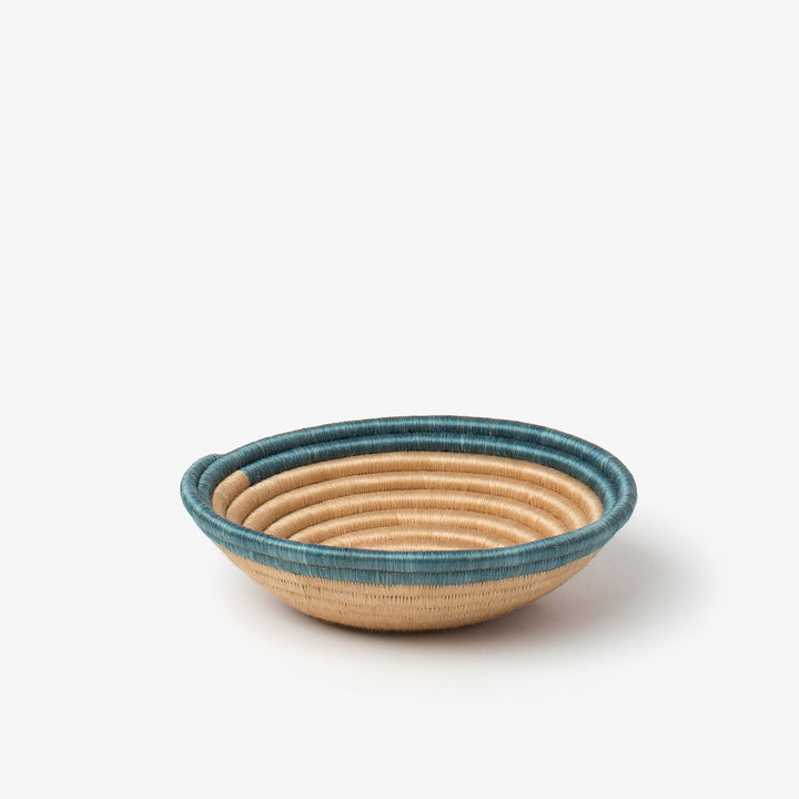 Small Aura woven bowl with a teal rim band over natural tea-toned sisal.