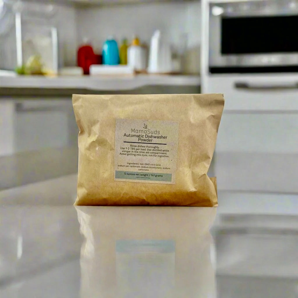 Sample of natural automatic dishwasher powder in a small container.