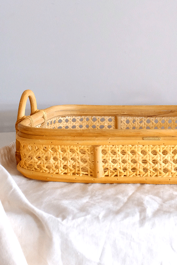 Handwoven rattan tray with cane weaving, for storage and serving.