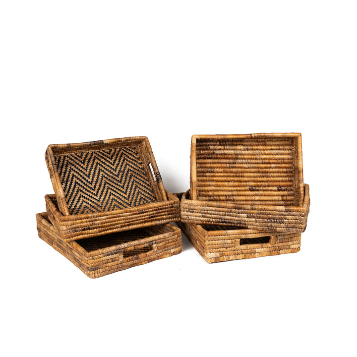 Set of natural woven banana leaf nesting trays on a white background.