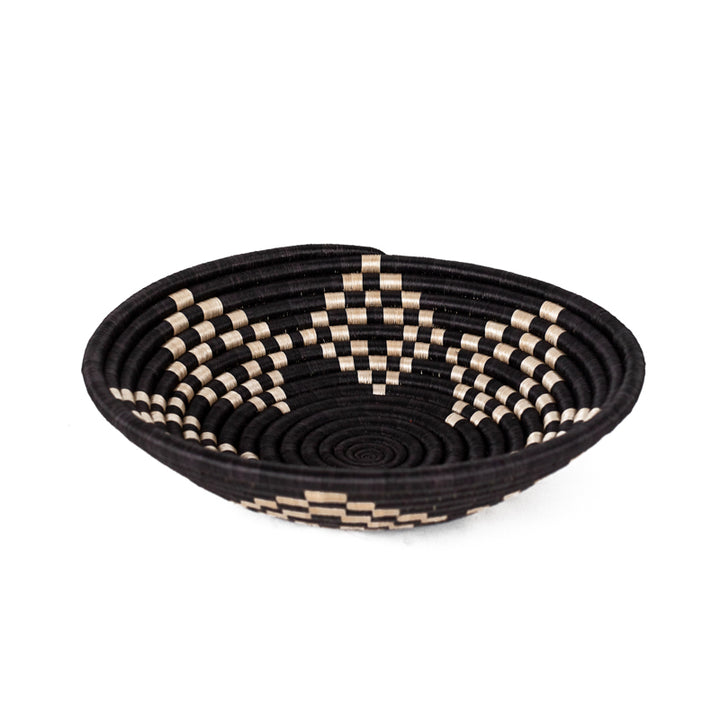 Bariku woven bowl in black, tan, and cream sisal with a geometric pattern.